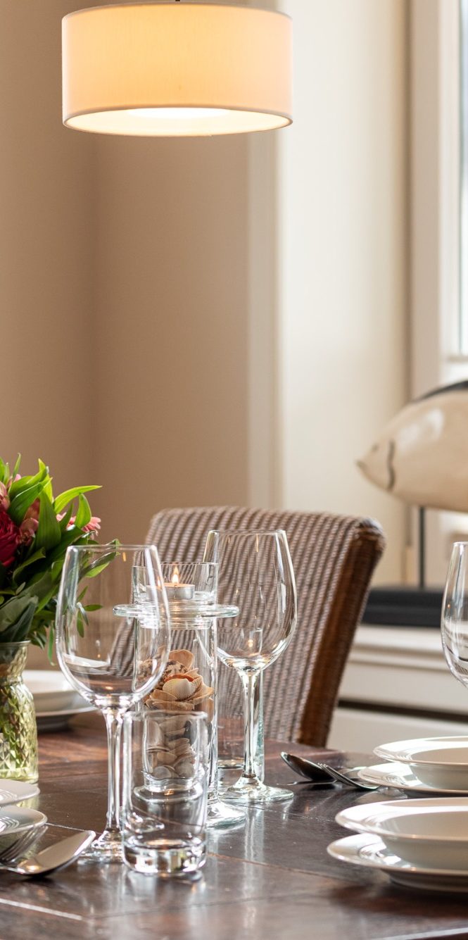 eingedeckter Tisch mit Weingläsern und Kerzen und Blumen 